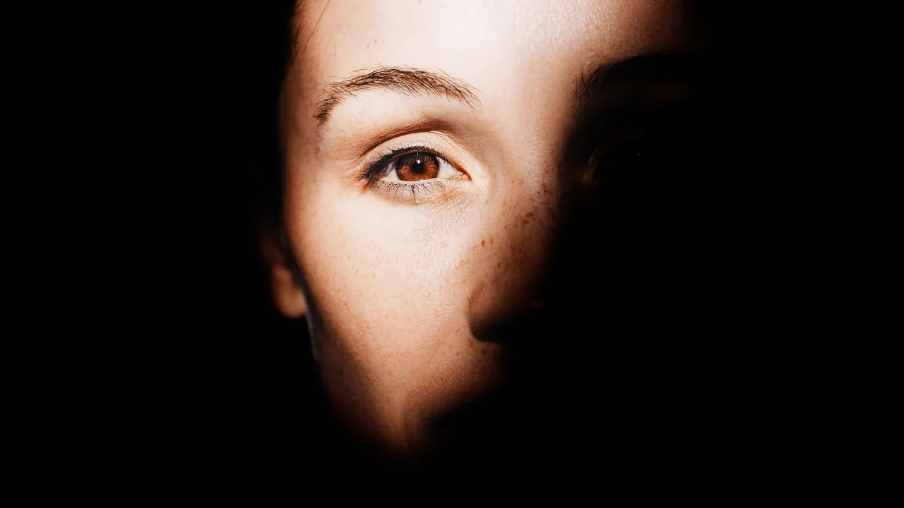 A face split between light and shadow to show lighting’s emotional effect