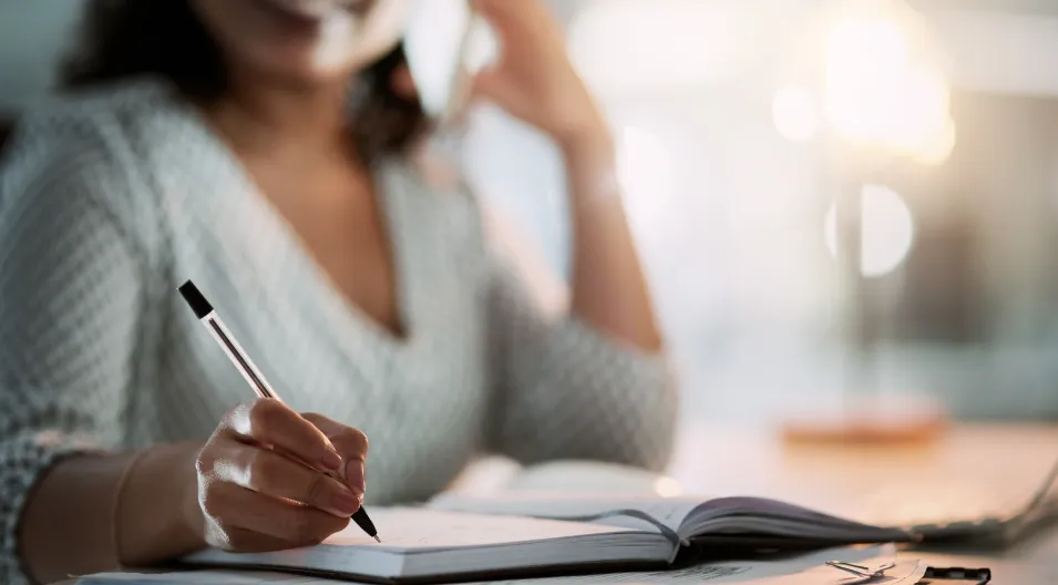 A customer writing notes while preparing a testimonial