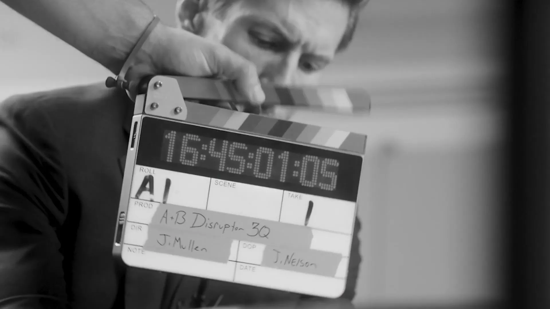 A crew member marking a shot with a film slate on a customer story shoot